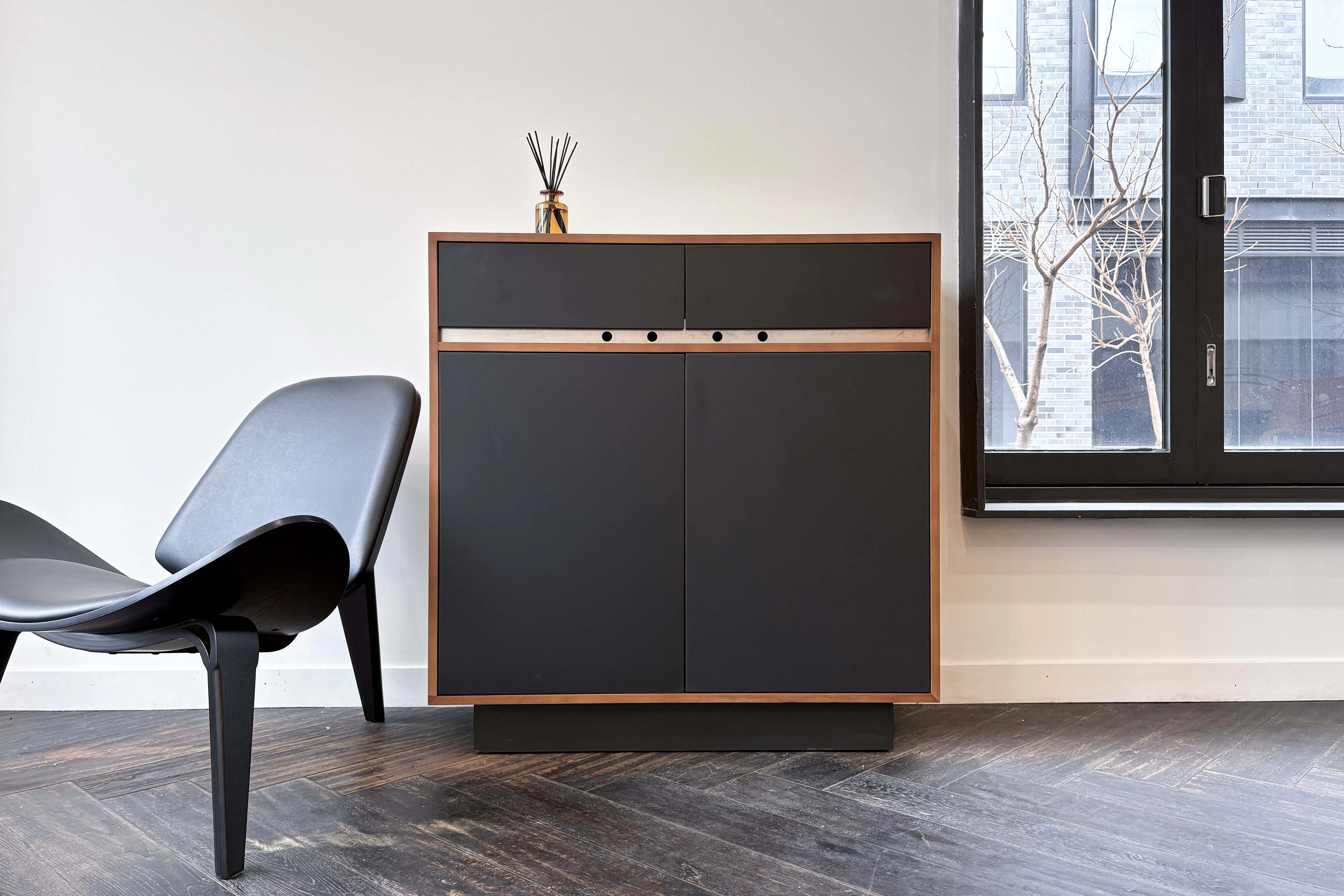 Richmond furniture showroom wall with dark cabinetry, a feature chair and controlled lighting.